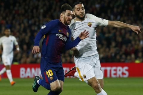 Barcelona's Lionel Messi, left, challenges for the ball with Roma's Kostas Manolas during a Champions League quarter-final, first leg soccer match between FC Barcelona and Roma at the Camp Nou stadium in Barcelona, Spain, Wednesday, April 4, 2018.(AP Photo/ Manu Fernandez)