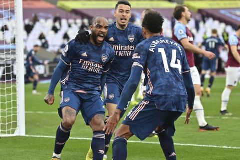 Arsenal's Alexandre Lacazette celebrates with his teammates after scoring his side's third goal during the English Premier League soccer match between West Ham United and Arsenal at the London Stadium in London, England, Sunday, March 21, 2021. (Justin Tallis, Pool via AP)