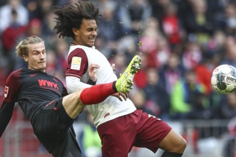 Bayern's Joshua Zirkzee, right, challenges for the ball with Augsburg's Tin Jedvaj during the German Bundesliga soccer match between FC Bayern Munich and FC Augsburg in Munich, Germany, Sunday, March 8, 2020. (AP Photo/Matthias Schrader)