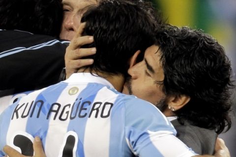 Argentina head coach Diego Maradona, right, kisses Sergio Aguero after the World Cup quarterfinal soccer match between Argentina and Germany at the Green Point stadium in Cape Town, South Africa, Saturday, July 3, 2010.  Germany won 4-0. (AP Photo/Gero Breloer)