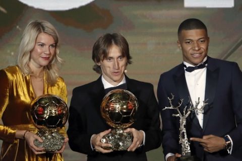 Real Madrid's Luka Modric, with the Ballon d'Or, center poses with Olympique Lyonnais' Ada Hegerberg with the Women's Ballon d'Or, left, and Paris St Germain's Kylian Mbappe with the Kopa Trophy, right, during the Golden Ball award ceremony at the Grand Palais in Paris, France, Monday, Dec. 3, 2018. Awarded every year by France Football magazine since Stanley Matthews won it in 1956, the Ballon d'Or, Golden Ball for the best player of the year will be given to both a woman and a man. (AP Photo/Christophe Ena)