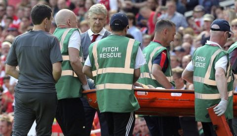 Arsenal's Arsene Wenger watches as Mohamed Elneny leaves the pitch injured on a stretcher during the English Premier League soccer match against West Ham United at the Emirates Stadium, London, Sunday April 22, 2018. (Mark Kerton/PA via AP)