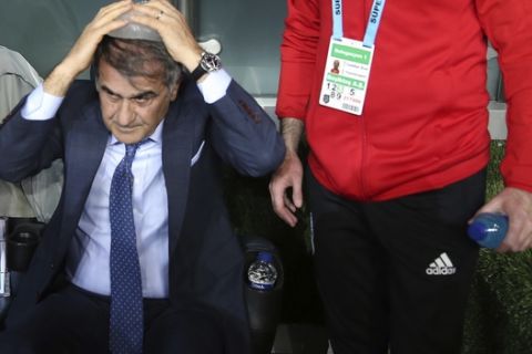 Besiktas coach Senol Gunes puts ice on his head after he suffered a head injury from an object, during the Turkish Cup semi-final second leg match between Besiktas and Fenerbahce in Istanbul, Thursday, April 19, 2018. The Turkish Cup semifinal between Fenerbahce and Besiktas was abandoned on Thursday after visiting coach Senol Gunes was injured by an object thrown from the stands. (AP Photo)