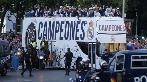 Real Madrid arrive on an open-topped bus with a police escort to Cibeles square to celebrate after winning the Champions League final, Madrid, Spain, Sunday June 4, 2017. Real Madrid became the first team in the Champions League era to win back-to-back titles with their 4-1 victory over Juventus in Cardiff Saturday. (AP Photo/Paul White)
