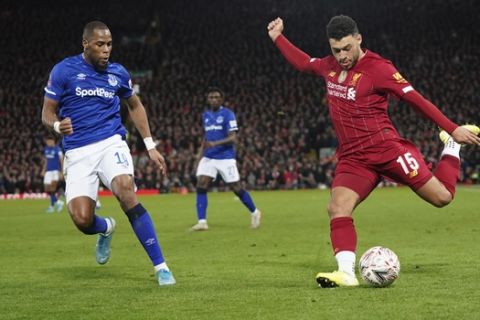 Liverpool's Alex Oxlade-Chamberlain, right, kicks the ball as Everton's Djibril Sidibe tries to stop him during the English FA Cup third round soccer match between Liverpool and Everton at Anfield stadium in Liverpool, England, Sunday, Jan. 5, 2020. (AP Photo/Jon Super)