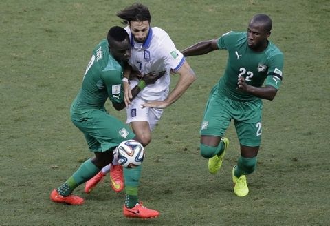 Ivory Coast's Cheik Tiote, left, holds back Greece's Giorgos Samaras (7) as he and teammate Sol Bamba (22) challenge for the ball during the group C World Cup soccer match between Greece and Ivory Coast at the Arena Castelao in Fortaleza, Brazil, Tuesday, June 24, 2014. (AP Photo/Sergei Grits)
