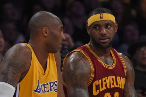 Los Angeles Lakers guard Kobe Bryant, left, and Cleveland Cavaliers forward LeBron James wait to come into the game during the first half of an NBA basketball game, Thursday, Jan. 15, 2015, in Los Angeles. (AP Photo/Mark J. Terrill) 
