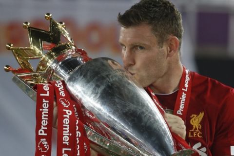 Liverpool's James Milner kisses the English Premier League trophy after its presentation following the during the English Premier League soccer match between Liverpool and Chelsea at Anfield Stadium in Liverpool, England, Wednesday, July 22, 2020. Liverpool won the game 5-3. (Phil Noble/Pool via AP)