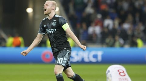 Ajax's Davy Klaassen celebrates reaching the final as Lyon's Corentin Tolisso, right,. is on the pitch after the second leg semi final soccer match between Olympique Lyon and Ajax in the Stade de Lyon, Decines, France, Thursday, May 11, 2017. Ajax lost 3-1, but continues to play the Europa League final after a 4-1 win at home. (AP Photo/Laurent Cipriani)