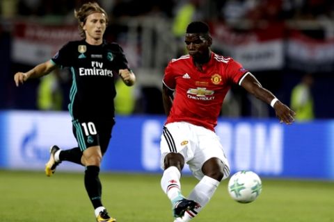 Manchester United's Paul Pogba, right, kicks the ball while being chased by Real Madrid's Lucas Modric during the Super Cup final soccer match between Real Madrid and Manchester United at Philip II Arena in Skopje, Tuesday, Aug. 8, 2017. (AP Photo/Thanassis Stavrakis)