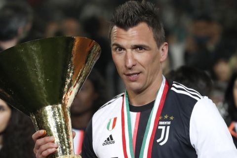 Juventus' Mario Mandzukic holds the Serie A soccer title trophy, at the Allianz Stadium in Turin, Italy, Sunday, May 19, 2019. (AP Photo/Antonio Calanni)