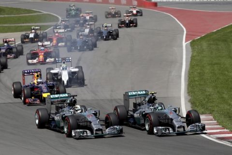 Mercedes driver Nico Rosberg (6) from Germany, and teammate Lewis Hamilton (44), from Great Britain, lead the pack out of the start during the Canadian Grand Prix Sunday, June 8, 2014, in Montreal. Rosberg finished second and Hamilton did not complete the race. (AP Photo/David J. Phillip)