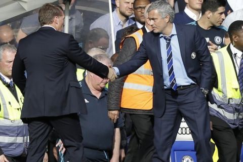 Liverpool's head coach Brendan Rodgers, left, shakes hands with Chelsea's head coach Jose Mourinho at the end of the English Premier League soccer match between Chelsea and Liverpool at Stamford Bridge stadium in London, Sunday, May 10,  2015. The game ended in a 1-1 draw. (AP Photo/Matt Dunham)