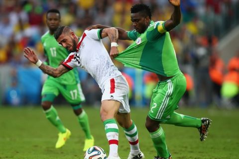 CURITIBA, BRAZIL - JUNE 16: Ashkan Dejagah of Iran pulls the jersey of Joseph Yobo of Nigeria during the 2014 FIFA World Cup Brazil Group F match between Iran and Nigeria at Arena da Baixada on June 16, 2014 in Curitiba, Brazil.  (Photo by Clive Rose/Getty Images)
