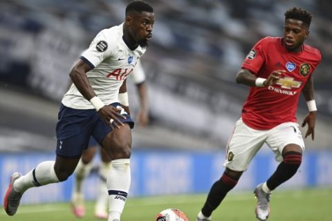 Tottenham's Serge Aurier runs with the ball during the English Premier League soccer match between Tottenham Hotspur and Manchester United at Tottenham Hotspur Stadium in London, England, Friday, June 19, 2020. (AP Photo/Shaun Botterill, Pool)