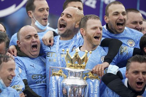 Manchester City's head coach Pep Guardiola, centre, celebrates winning the English Premier League title after the soccer match between Manchester City and Everton at the Etihad stadium in Manchester, Sunday, May 23, 2021.(AP Photo/Dave Thompson, Pool)
