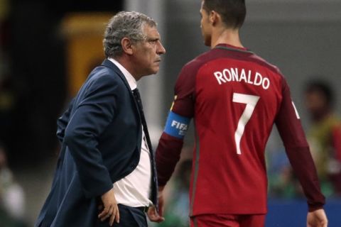 Portugal's Cristiano Ronaldo walks by Portugal coach Fernando Santos during the Confederations Cup, semifinal soccer match between Portugal and Chile, at the Kazan Arena, Russia, Wednesday, June 28, 2017. (AP Photo/Ivan Sekretarev)