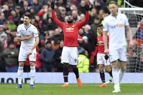 Manchester United's Romelu Lukaku, centre, celebrates scoring his side's first goal of the game against Swansea, during the Premier League soccer match at Old Trafford in Manchester, England, Saturday March 31, 2018.(Anthony Devlin/PA via AP)