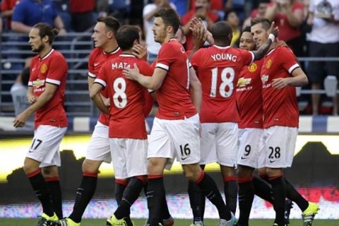 Manchester United's Morgan Schneiderlin (28), right, celebrates with teammates after he scored a goal against Club America during the first half of an international friendly soccer match, Friday, July 17, 2015, in Seattle. (AP Photo/Ted S. Warren)