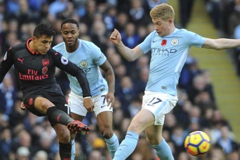 Arsenal's Alexis Sanchez, left, and Manchester City's Kevin De Bruyne, right, battle for the ball watched by Manchester City's Raheem Sterling, centre, during the English Premier League soccer match between Manchester City and Arsenal at Etihad stadium, Manchester, England, Sunday, Nov. 5, 2017. (AP Photo/Rui Vieira)
