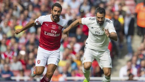 Arsenal Legends' Robert Pires, left, and Real Madrid Legends' Fernando Sanz race for the ball during the Legends match at the Emirates Stadium in London, Saturday Sept. 8, 2018. (Dominic Lipinski/PA via AP)