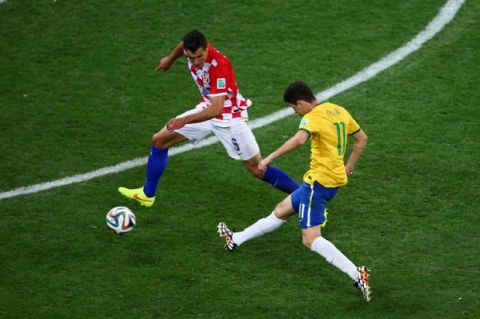 SAO PAULO, BRAZIL - JUNE 12: Oscar of Brazil shoots and scores against Dejan Lovren of Croatia in the second half during the 2014 FIFA World Cup Brazil Group A match between Brazil and Croatia at Arena de Sao Paulo on June 12, 2014 in Sao Paulo, Brazil.  (Photo by Elsa/Getty Images)