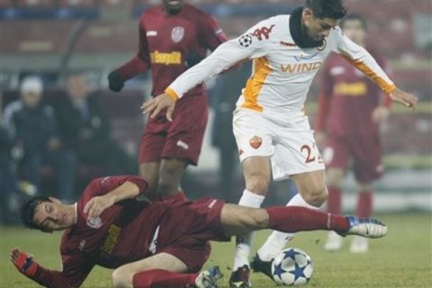 Marco Borriello, of AS Roma, right, fights for the ball with Ionut Rada, of CFR Cluj, left,  in Cluj, Romania, Wednesday, Dec. 8, 2010, during a Group E Champions League match.(AP Photo/Vadim Ghirda)