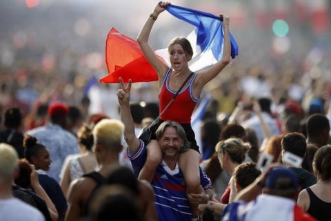 People celebrate on the Champs Elysees avenue after France won the soccer World Cup final match between France and Croatia, Sunday, July 15, 2018 in Paris. France won its second World Cup title by beating Croatia 4-2 . (AP Photo/Francois Mori)