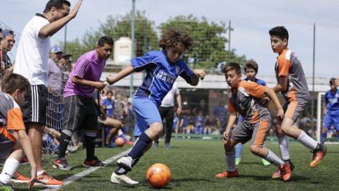 In this Nov. 19, 2016 photo, Thiago "Coco" Perugini controls the ball during a youth league game on the outskirts of in Buenos Aires, Argentina. "The day that he doesn't want to play anymore, it all ends right here. He has to be a good person and study and he has the support of his parents," said Thiago's dad, Diego Perugini, a former lower division soccer player who is a coach at Parque. (AP Photo/Natacha Pisarenko)