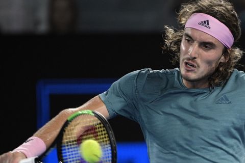 Greece's Stefanos Tsitsipas makes a backhand return to Switzerland's Roger Federer during their fourth round match at the Australian Open tennis championships in Melbourne, Australia, Sunday, Jan. 20, 2019. (AP Photo/Andy Brownbill)