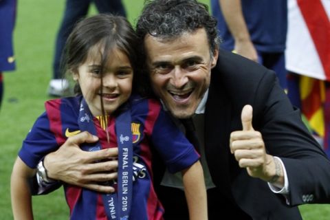 Barcelona's head coach Luis Enrique celebrates with his daughter Xana on top of the trophy after winning 3-1 the Champions League final soccer match between Juventus Turin and FC Barcelona at the Olympic stadium in Berlin Saturday, June 6, 2015. (AP Photo/Michael Probst)