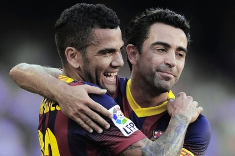 FC Barcelona's Daniel Alves, from Brazil, left, reacts after scoring with his teammate Xavi Hernandez against Levante during a Spanish La Liga soccer match at the Camp Nou stadium in Barcelona, Spain, Sunday, Aug. 18, 2013. (AP Photo/Manu Fernandez)