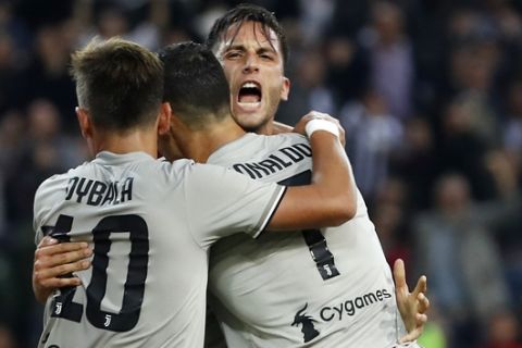 Juventus' Rodrigo Bentancur, right, celebrates with his teammates Paulo Dybala, left, and Cristiano Ronaldo after scoring his side's opening goal during the Serie A soccer match between AC Udinese and Juventus at the Dacia Arena Stadium, in Udine, Italy, Saturday, Oct. 6, 2018. (AP Photo/Antonio Calanni)