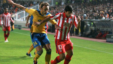 APOEL's Christos Kontis, left, fights for the ball with Atletico de Madrid's Sergio Aguero, right, of Argentina, during a group D Champions League soccer match at GSP stadium in Nicosia, Cyprus, Wednesday, Nov. 25, 2009. (AP Photo/Philippos Christou)
