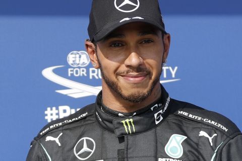 Mercedes driver Lewis Hamilton of Britain poses after he clocked the fastest time during the qualifying session for the Hungarian Formula One Grand Prix, at the Hungaroring racetrack in Mogyorod, Hungary, Saturday, July 31, 2021. The Hungarian Formula One Grand Prix will be held on Sunday. (David W Cerny/Pool via AP)