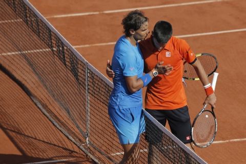Serbia's Novak Djokovic hugs Spain's Rafael Nadal, left, after winning the quarterfinal match of the French Open tennis tournament in three sets, 7-5, 6-3, 6-1, at the Roland Garros stadium, in Paris, France, Wednesday, June 3, 2015. (AP Photo/Christophe Ena)