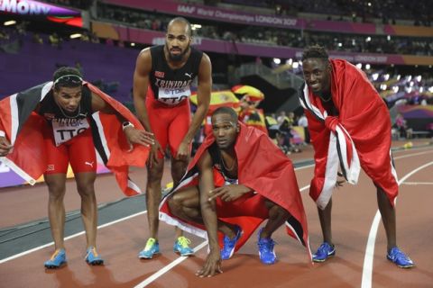 Trinidad and Tobago's gold medal winning team, from left, Jarrin Solomon, Machel Cedenio, Lalonde Gordon and Jereem Richards celebrate after winning the gold in the men's 4x400-meter relay final during the World Athletics Championships in London Sunday, Aug. 13, 2017. (AP Photo/Matthias Schrader)