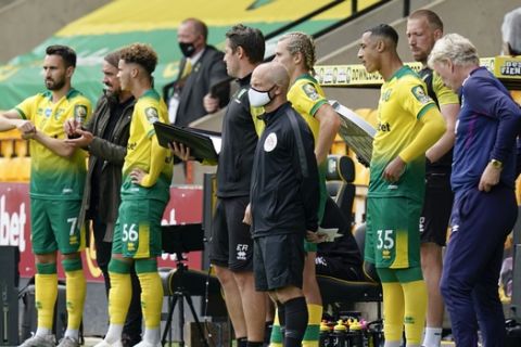 Norwich City's head coach Daniel Farke, left, makes a quadruple substitution during the English Premier League soccer match between Norwich City and West Ham at the Carrow Road stadium in Norwich, England, Saturday, July 11, 2020. (Tim Keeton/Pool via AP)