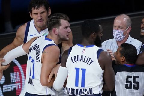 Dallas Mavericks' Luka Doncic (77) argues with players after being fouled by Los Angeles Clippers' Marcus Morris Sr. during the first half of an NBA first round playoff game Sunday, Aug. 30, 2020, in Lake Buena Vista, Fla. (AP Photo/Ashley Landis)