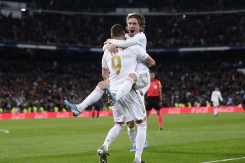Real Madrid's Luka Modric celebrates with Karim Benzema after scoring his side's third goal during the Spanish La Liga soccer match between Real Madrid and Real Sociedad at the Bernabeu stadium in Madrid, Spain, Spain, Saturday, Nov. 23, 2019. (AP Photo/Manu Fernandez)