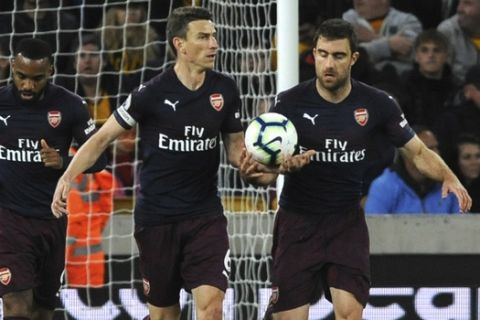 Arsenal's Sokratis Papastathopoulos, right, celebrates after scoring his side's opening goal during the English Premier League soccer match between Wolverhampton Wanderers and Arsenal at the Molineux Stadium in Wolverhampton, England, Wednesday, April 24, 2019. (AP Photo/Rui Vieira)