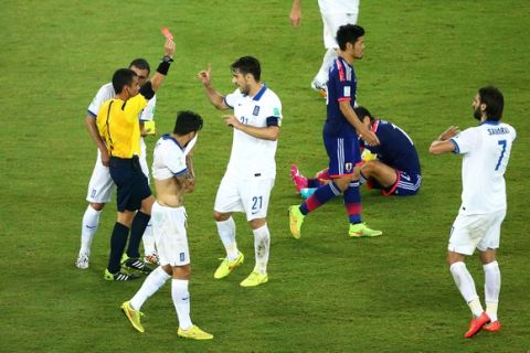 NATAL, BRAZIL - JUNE 19:  Konstantinos Katsouranis #21 of Greece is shown a red card after receiving his second yellow by referee Joel Aguilar during the 2014 FIFA World Cup Brazil Group  C match between Japan and Greece at Estadio das Dunas on June 19, 2014 in Natal, Brazil.  (Photo by Robert Cianflone/Getty Images)