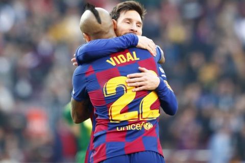 Barcelona's Lionel Messi, right, celebrates with Arturo Vidal after scoring his side's second goal during a Spanish La Liga soccer match between Barcelona and Eibar at the Camp Nou stadium in Barcelona, Spain, Saturday Feb. 22, 2020. (AP Photo/Joan Monfort)