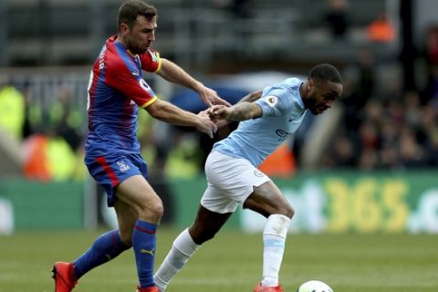 Crystal Palace's James McArthur, left, and Manchester City's Raheem Sterling  battle for the ball during their English Premier League soccer match at Selhurst Park, London, Sunday, April 14, 2019. (Steven Paston/PA via AP)