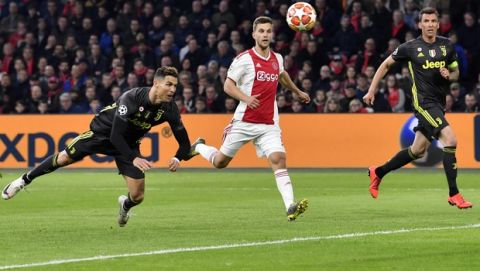 Juventus' Cristiano Ronaldo, left, scores his side's opening goal during the Champions League quarterfinal, first leg, soccer match between Ajax and Juventus at the Johan Cruyff ArenA in Amsterdam, Netherlands, Wednesday, April 10, 2019. (AP Photo/Martin Meissner)
