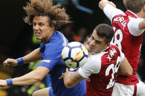 Chelsea's David Luiz, Arsenal's Granit Xhaka, and Arsenal's Nacho Monreal, from left, jump to head the ball during the English Premier League soccer match between Chelsea and Arsenal at Stamford Bridge stadium in London, Sunday, Sept. 17, 2017. (AP Photo/Frank Augstein)