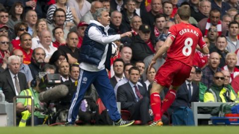 Chelsea's manager Jose Mourinho, left, keeps the ball from Liverpool's Steven Gerrard during their English Premier League soccer match at Anfield Stadium, Liverpool, England, Sunday April 27, 2014. (AP Photo/Jon Super)    