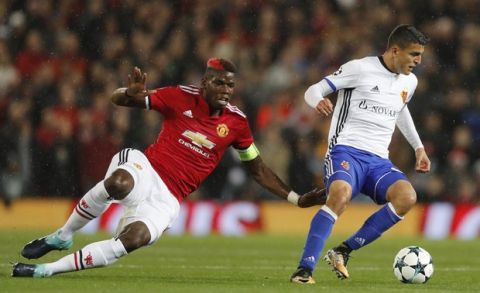 Basel's Mohamed Elyounoussi, right, is challenged by Manchester United's Paul Pogba during the Champions League group A soccer match between Manchester United and Basel, at the Old Trafford stadium in Manchester, Tuesday, Sept. 12, 2017. (AP Photo/Frank Augstein)