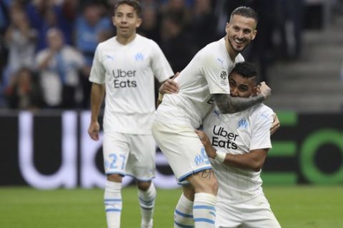 Marseille's Dimitri Payet, right, Marseille's Dario Benedetto, Marseille's Maxime Lopez celebrate after Lille's Gabriel scored an own goal during the French League One soccer match between Marseille and Lille at the Velodrome stadium in Marseille, southern France, Saturday, Nov. 2, 2019. (AP Photo/Daniel Cole)