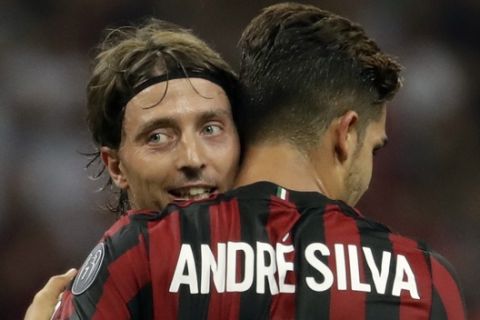 AC Milan's Andre Silva, right, celebrates with Riccardo Montolivo after scoring his side's third goal during the Europa League, play-off, first-leg soccer match between AC Milan and Shkendija, at the Milan San Siro Stadium, Italy, Thursday, Aug.17, 2017. (AP Photo/Antonio Calanni)